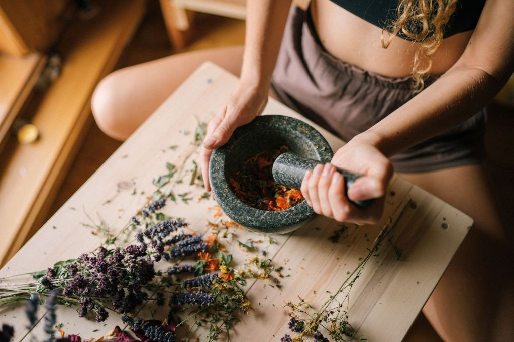 a person smashing herbs using a mortar